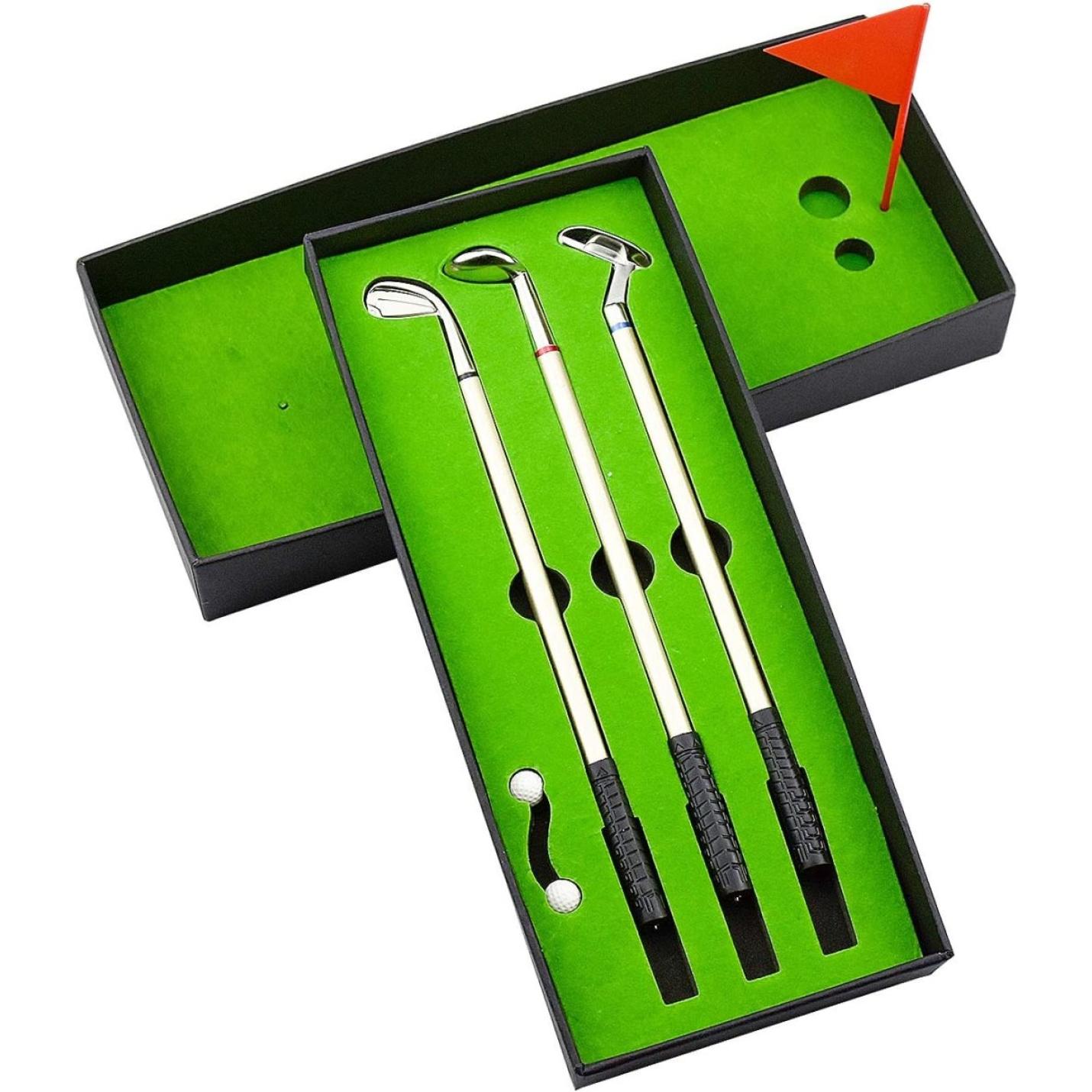 Een set Elegantie en plezier met de minigolfclubs en een rode vlag in een groen omlijnde doos, ontworpen om op een golfbaan te lijken, perfect als bureaubladdecoratie.