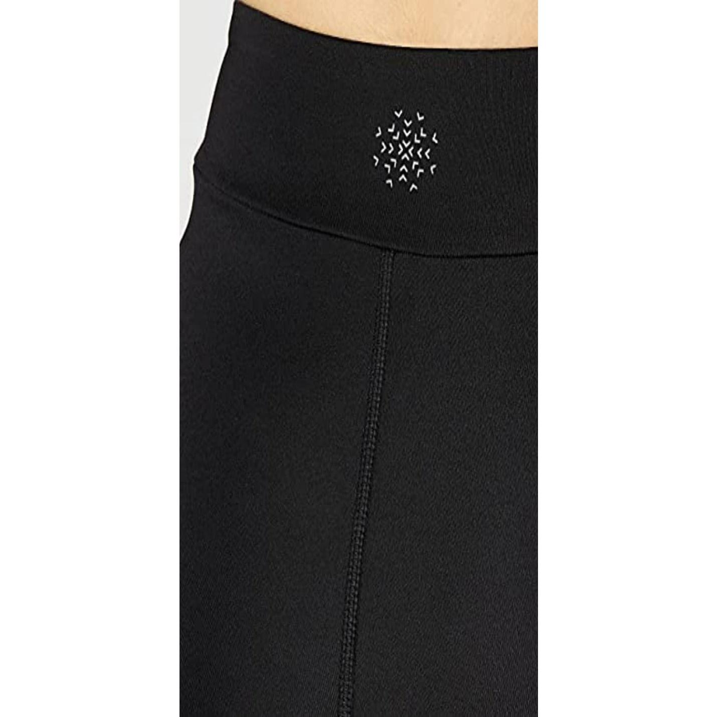 Close-up van de Ervaar comfort en stijl met onze sportlegging voor dames tailleband met ritssluiting en een decoratief patroon van witte geborduurde sterren.