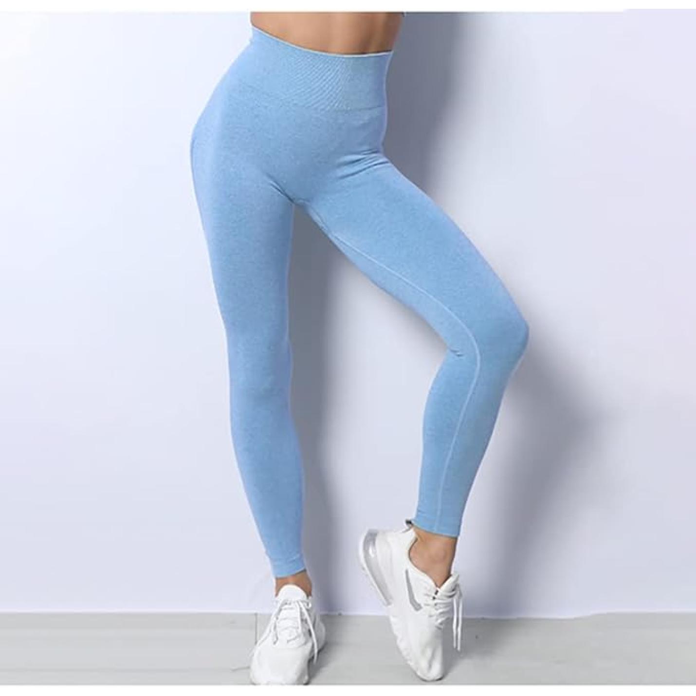 Een vrouw die lichtblauw Zie er geweldig uit en voel je geweldig draagt in deze 3-delige yoga-workoutset en witte sneakers staat tegen een grijze achtergrond, waardoor het zijprofiel van de legging goed zichtbaar is.