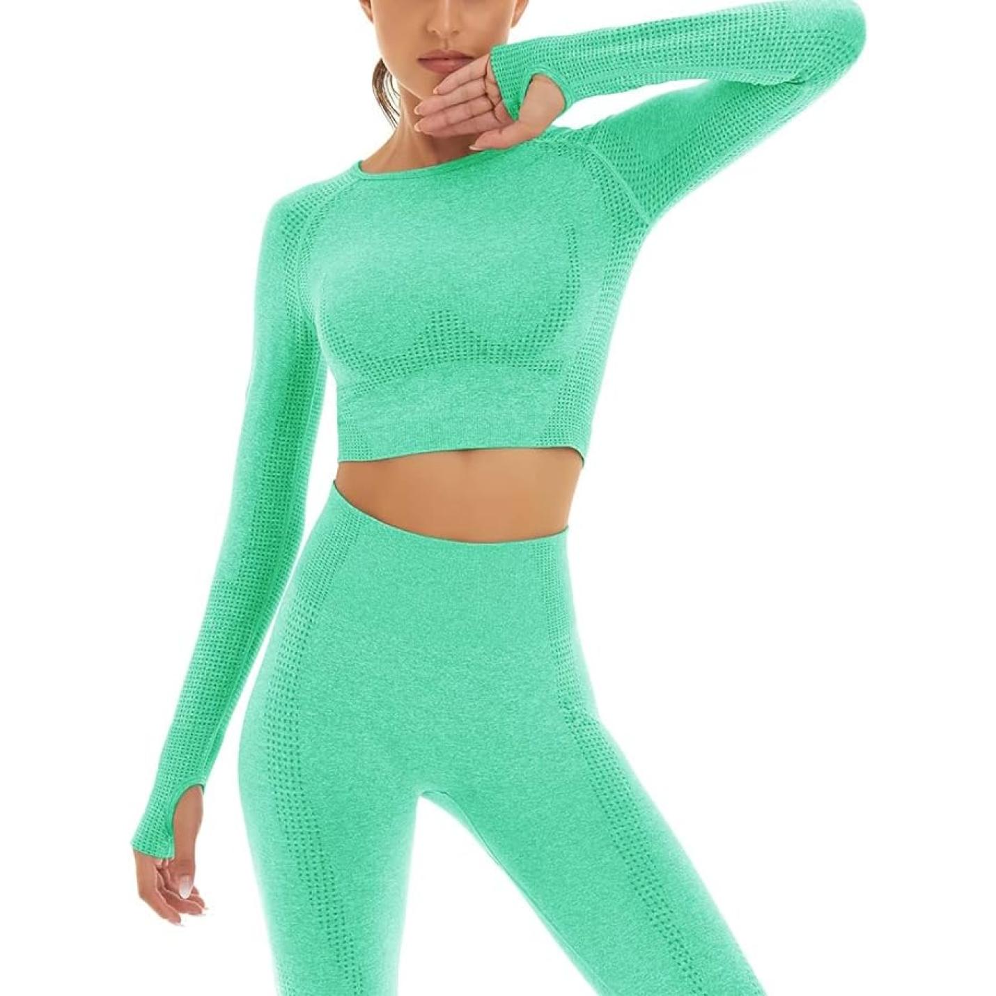 Vrouw in felgroen, zie er geweldig uit en voel je geweldig in deze hoge taille legging en cropped sporttop, poserend met één hand op haar kin.