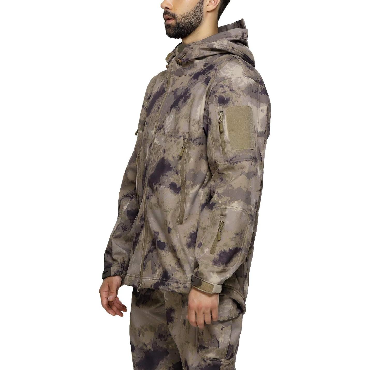 Man met een camouflage tactische heren softshell jas met capuchon, naar de zijkant kijkend, tegen een effen achtergrond.