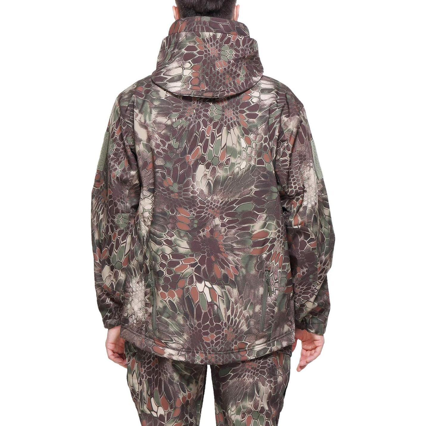 Achteraanzicht van een persoon die een camouflage tactische softshell herenjas en -broek draagt met een bloemen- en reptielenhuidpatroon, staande tegen een effen achtergrond.