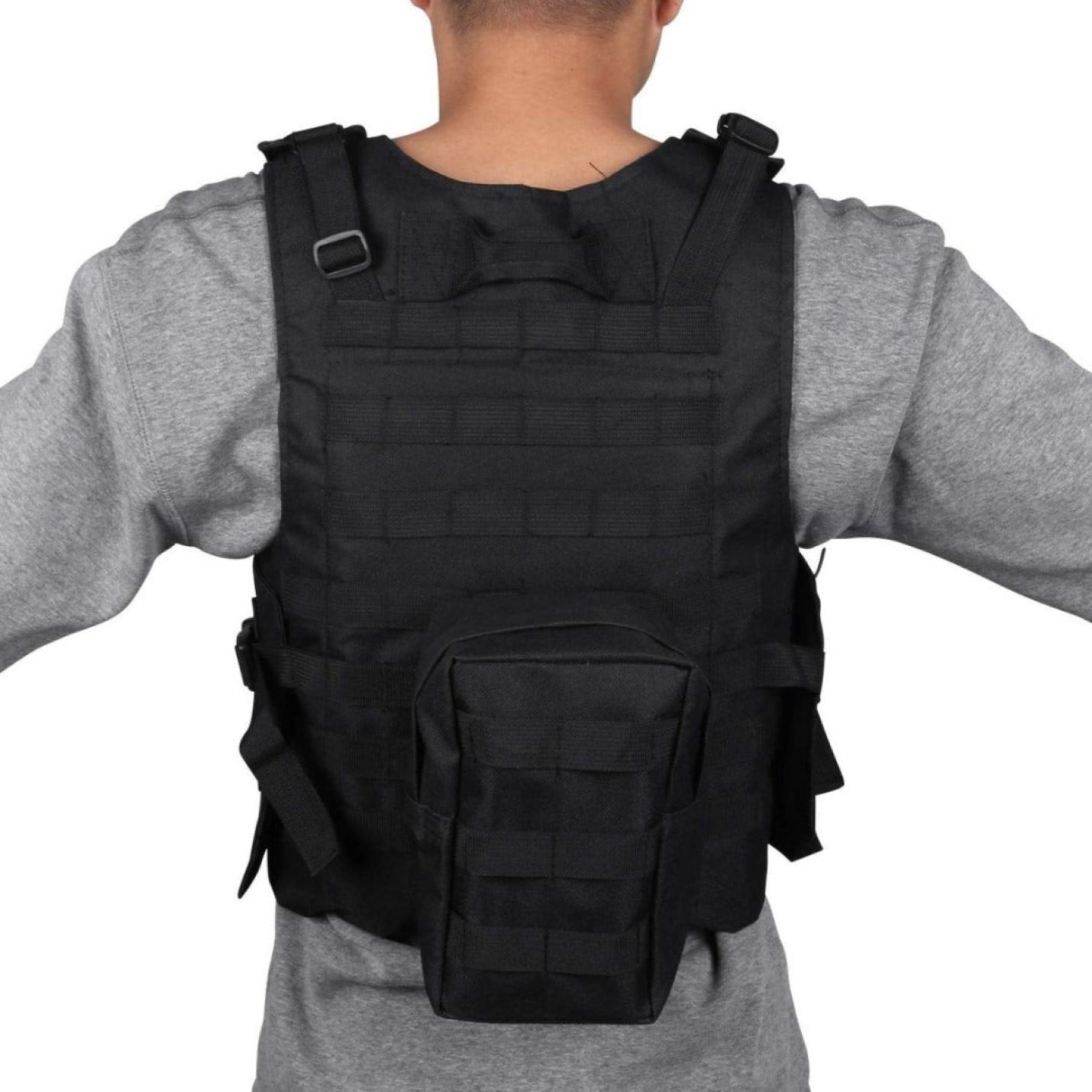 Een persoon die een zwarte Ontketen draagt, je ware potentieel met het verstelbare tactische vest voor paintball met zakken over een grijs shirt met lange mouwen, gezien vanaf de achterkant.