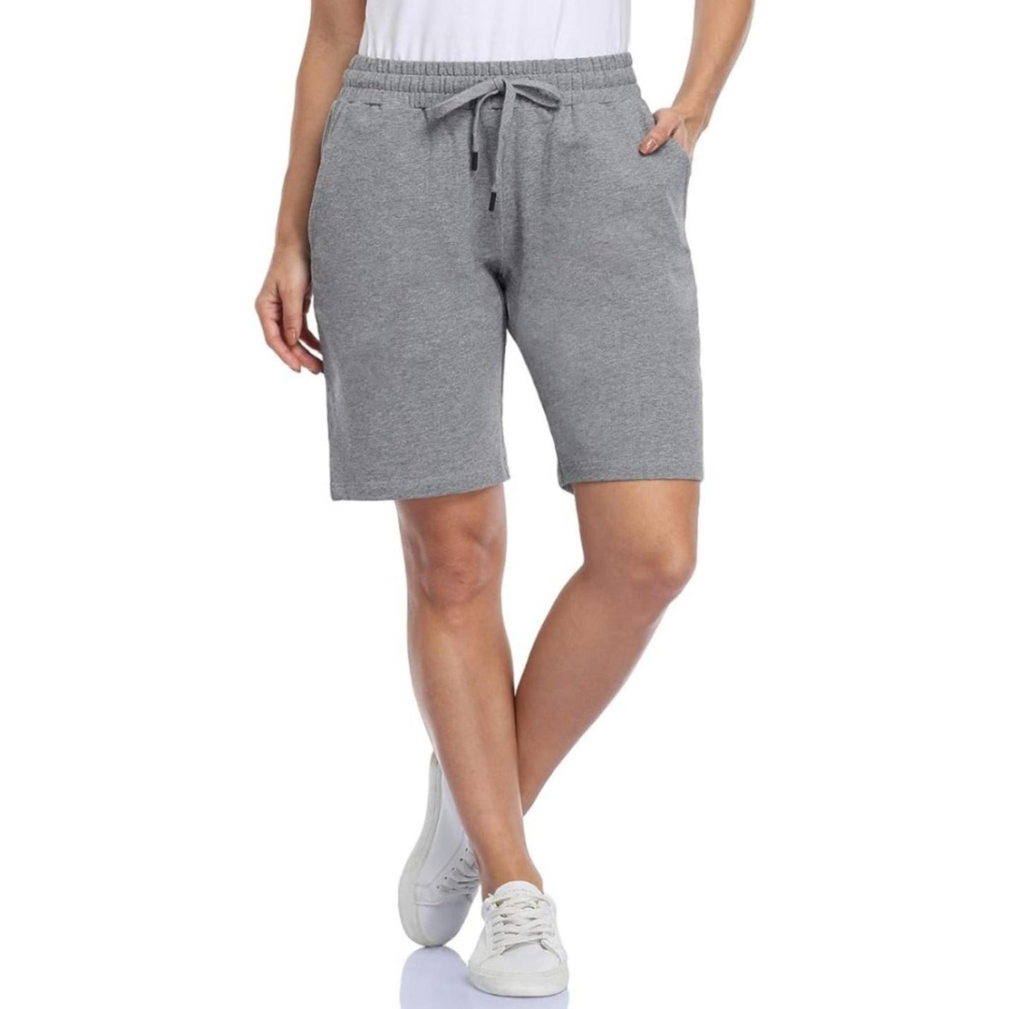 Vrouw draagt Bermudashort voor dames en witte sneakers.