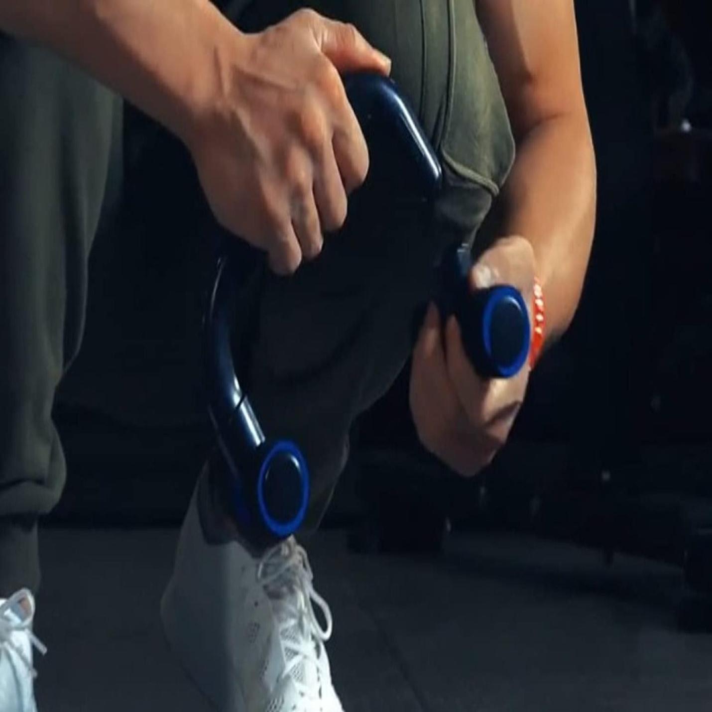 Close-up van een persoon die de fitnessset Transformeer je lichaam met de veelzijdige buiktrainer voor zijn bovenlichaam gebruikt, gekleed in een grijs shirt en witte sneakers.