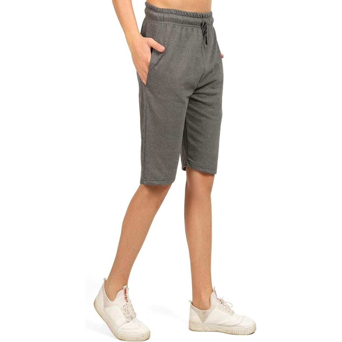 Persoon draagt Comfortabele, ruime bermudashorts voor heren in grijs met zakken en witte sneakers.