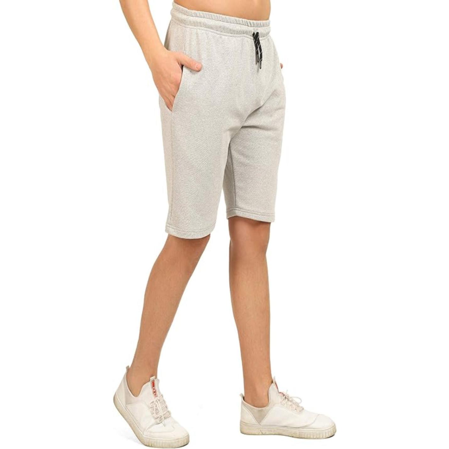 Persoon draagt comfortabele, ruime bermudashorts voor heren van geweven stof en witte sneakers.