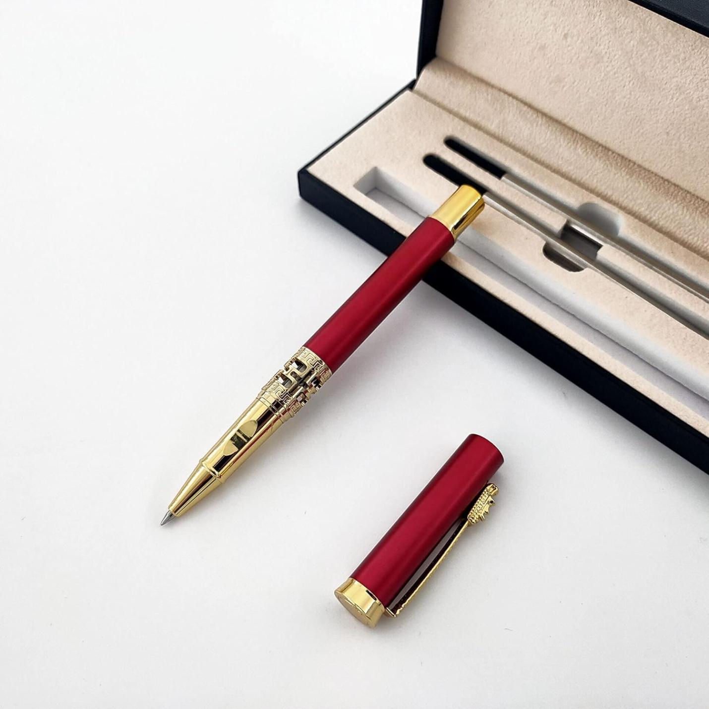 Een elegante rode en gouden Een klassieke metalen rollerball voor een luxe schrijfervaring, liggend naast de dop en een presentatiedoos.