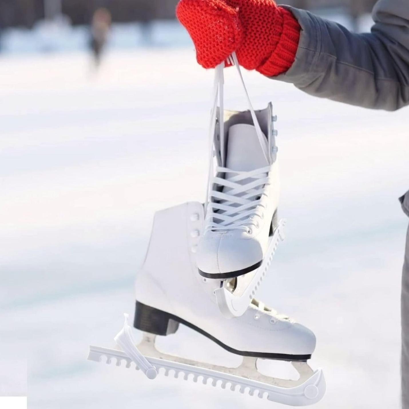 Een persoon die rode wanten draagt en een witte schaats vasthoudt met Schaatsbeschermers buitenshuis.