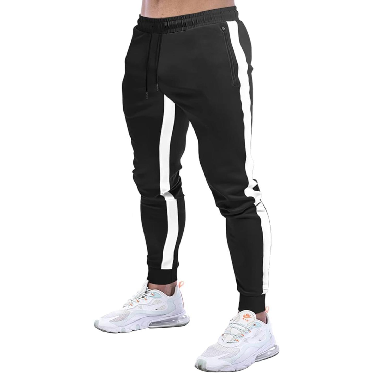 Een persoon draagt stijlvolle zwarte joggingbroek voor heren met witte zijstrepen en witte sneakers.