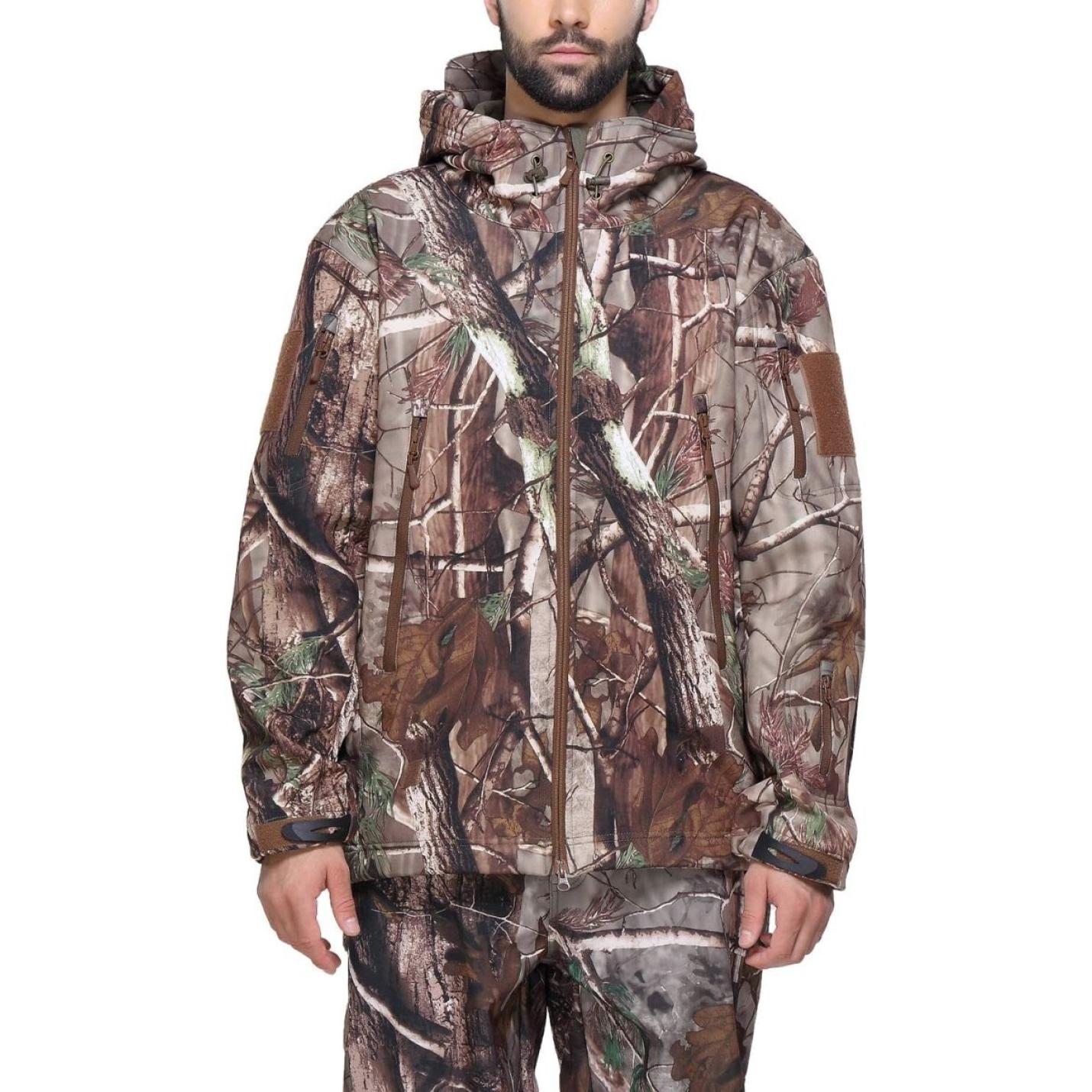 Man met een camouflage tactische heren softshell jas met capuchon, staande tegen een effen achtergrond.