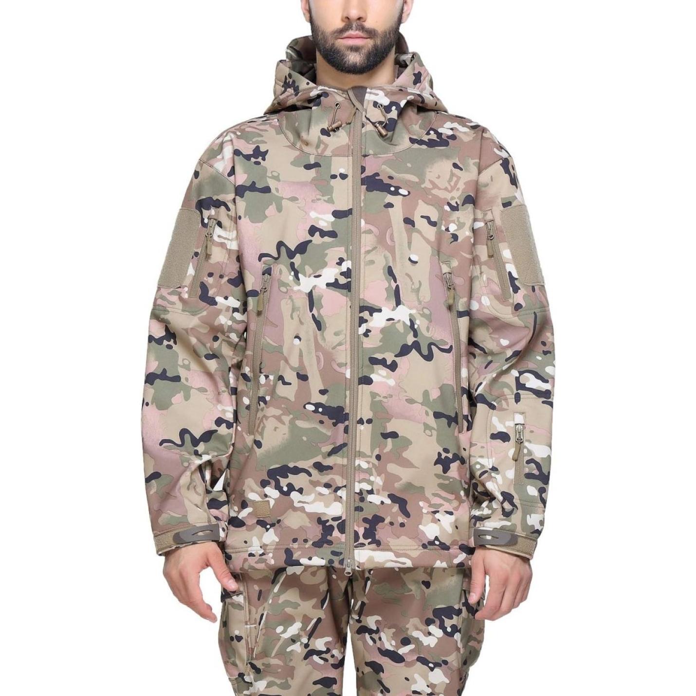 Man met een camouflage tactische heren softshell jas met meerdere zakken, een capuchon en klittenbandpatches op de mouwen.