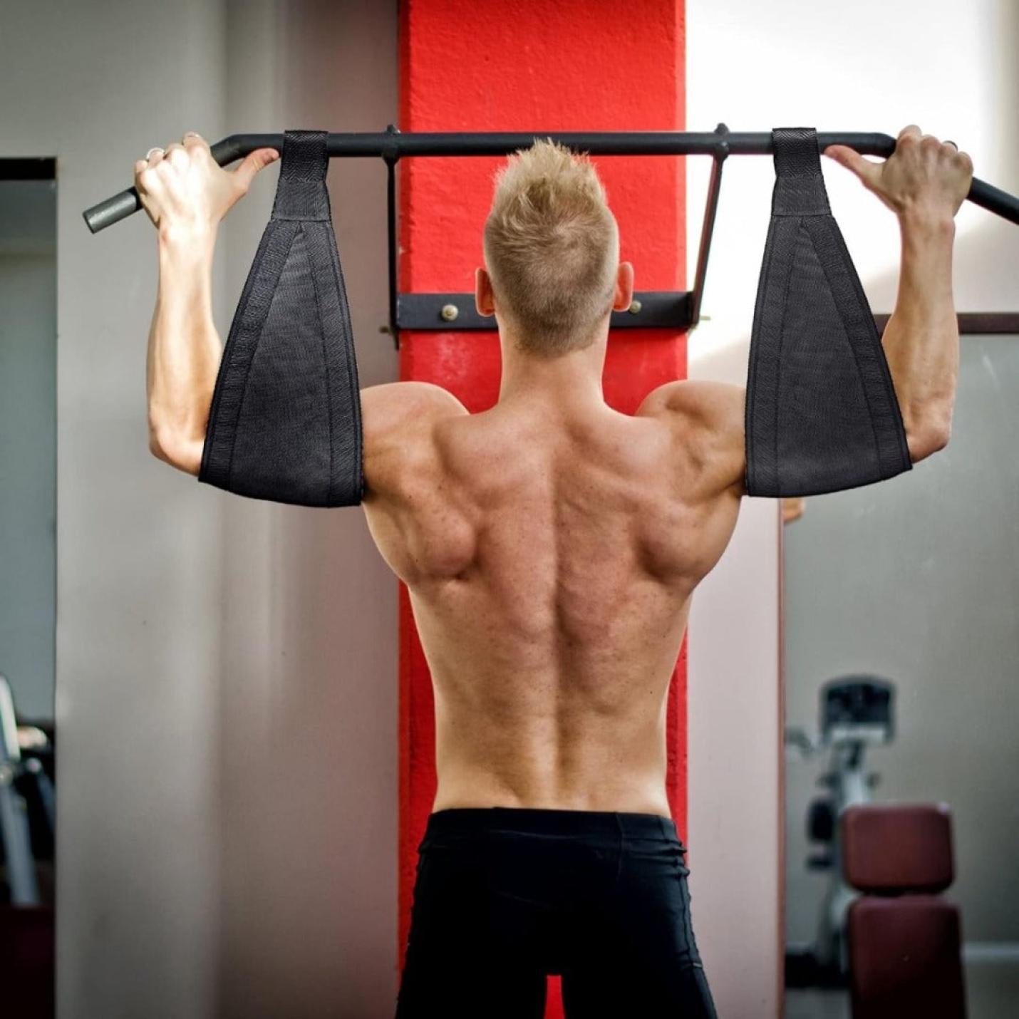 Man voert pull-ups uit met behulp van een apparaat met geassisteerde grip en Ontdek de kracht van de buikspierlussen en krijg de buik van je dromen! in de sportschool.