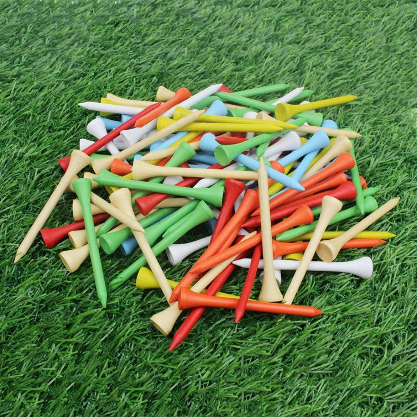 Een stapel professionele houten golftees verspreid over een grasveld.