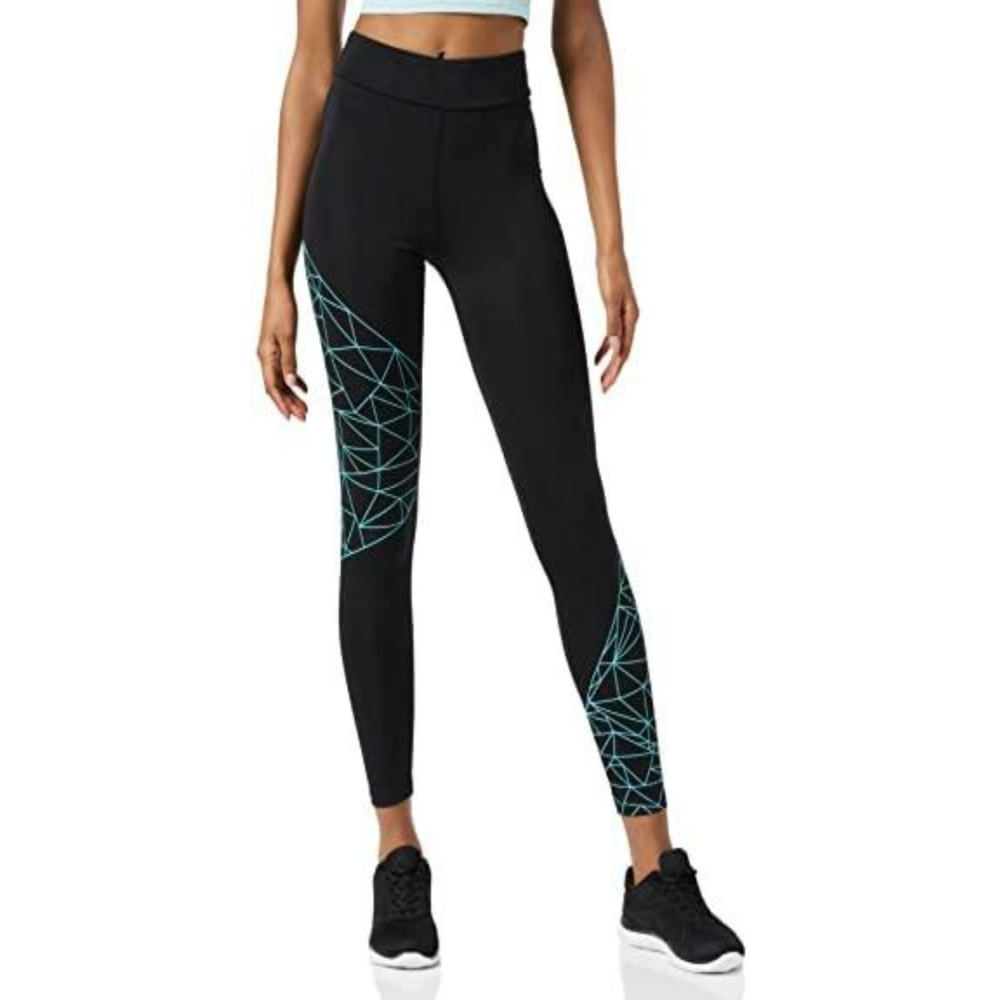 Een vrouw staande in Ervaar comfort en stijl met onze sportlegging voor dames met een blauwgroen geometrisch patroon, zwarte schoenen dragend, cropped in de taille.