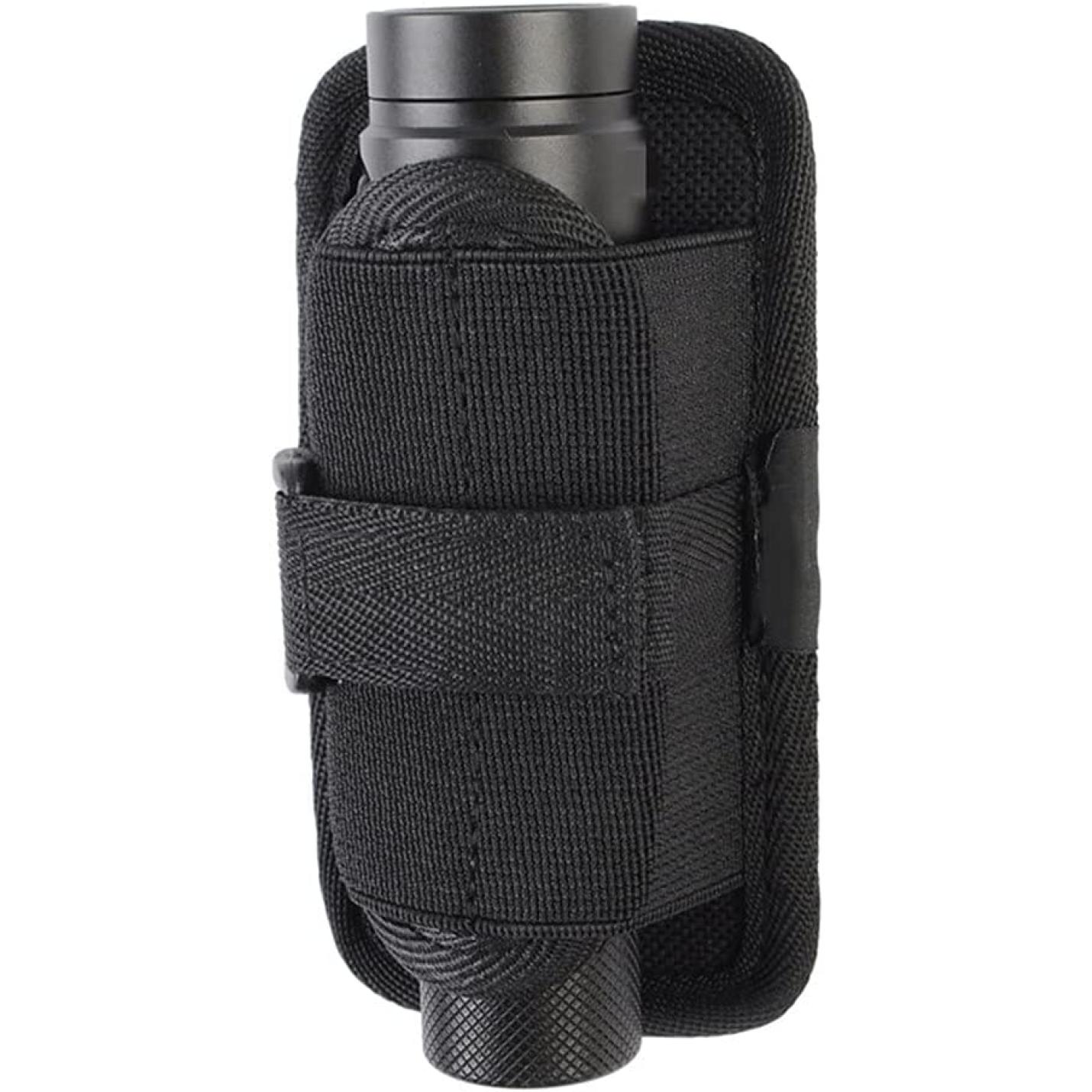 Een zwarte Tactische molle zaklamp-holster in een bijpassende nylon holster met klittenband, bevestigd aan een geweven stoffen oppervlak.