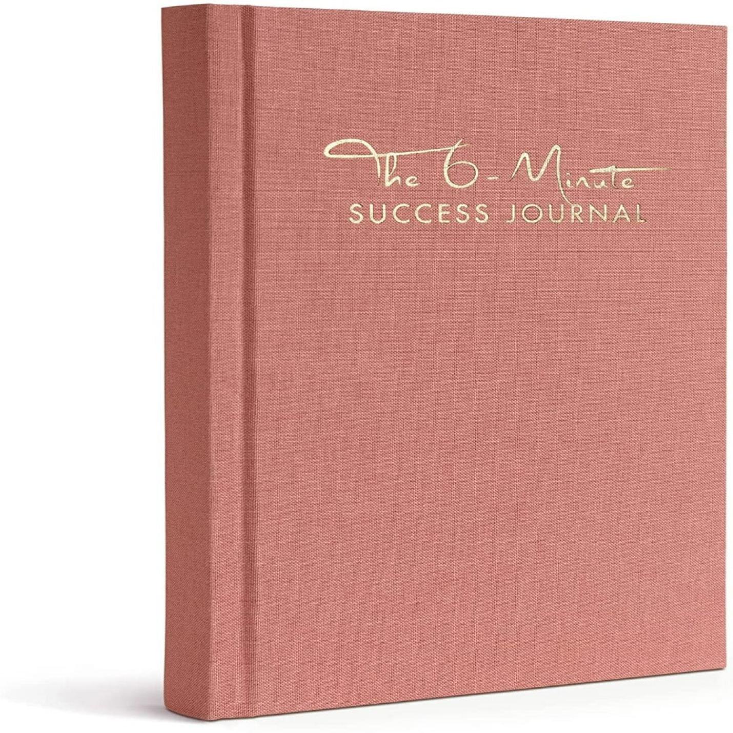 Een roze hardcover dagboek met de titel "Het 6-Minute Success Journal: Transformeer je Leven met Slechts 6 Minuten Per Dag!" weergegeven op een neutrale achtergrond, ontworpen om de productiviteit en mindfulness te verbeteren.