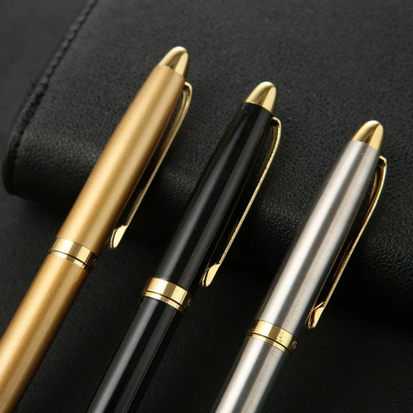 Drie elegante Upgrade uw schrijfervaring met de luxe metalen balpennen in goud, zwart en zilver, diagonaal gerangschikt op een donker oppervlak. Deze perfecte cadeauartikelen zijn gemaakt van hoogwaardig metaal.