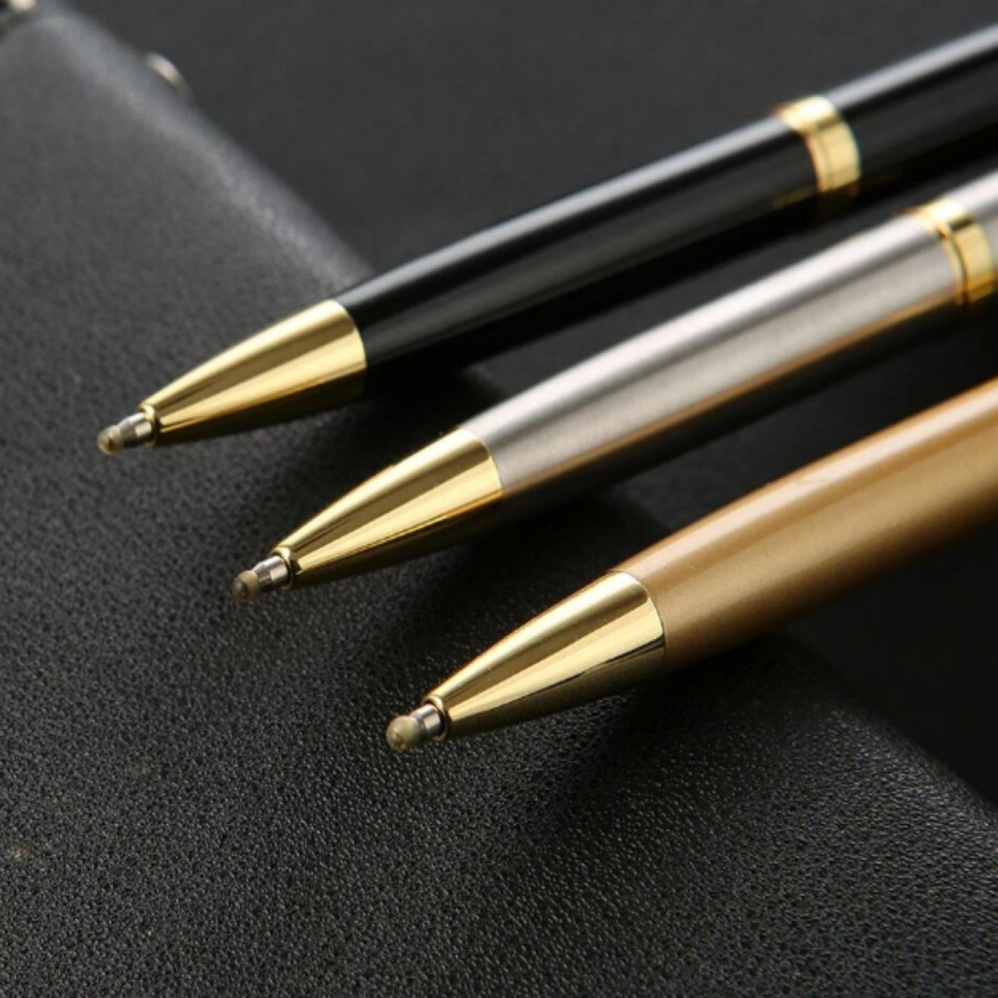 Upgrade uw schrijfervaring met de luxe metalen balpen met gouden en zilveren accenten, rustend op een zwart oppervlak.