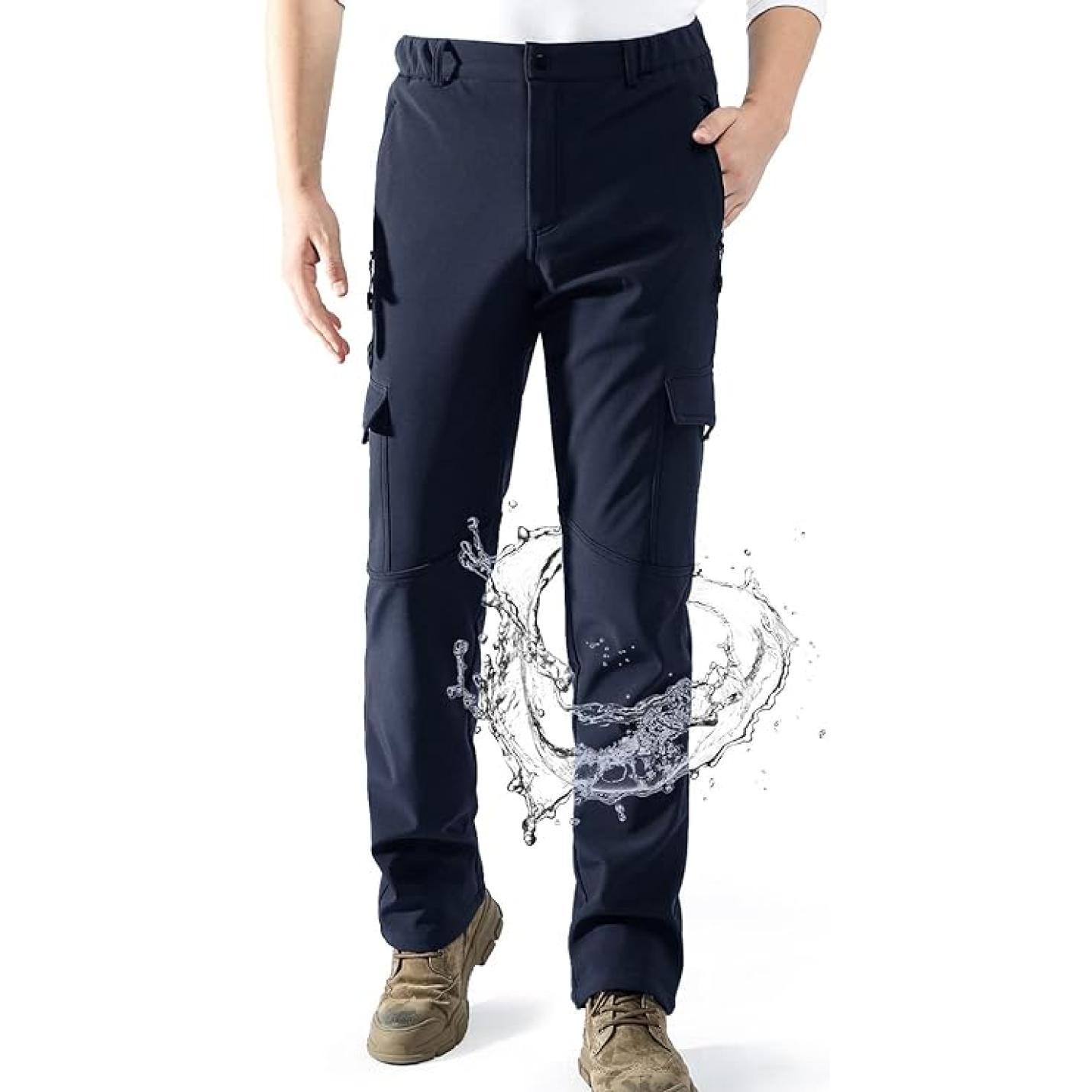 Person modeling waterdichte, gevoerde outdoorbroek met grafisch opspattend watereffect aan de onderkant, voorzien van een comfortabele pasvorm.